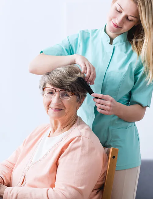 A carer helping a client with her hair at home